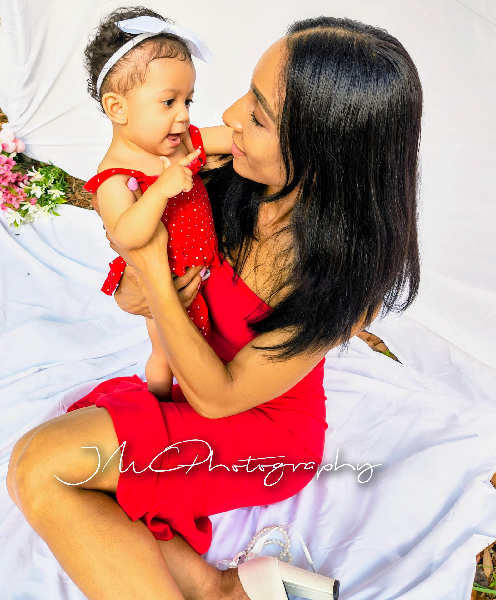 Mother and baby daughter sharing a tender moment in red