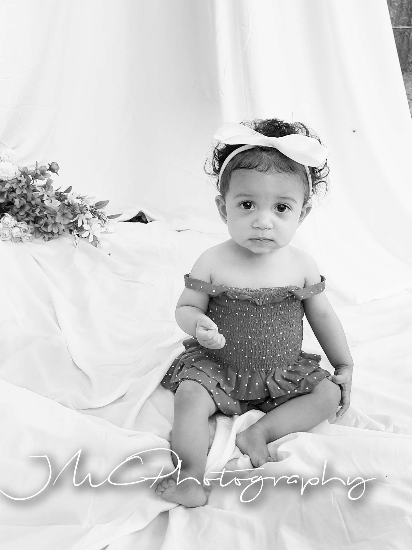 Black and white portrait of baby girl with white bow